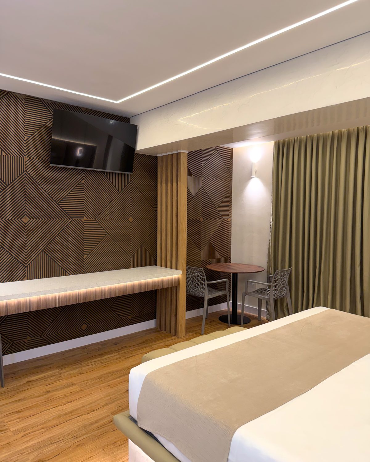 King VIP: escritorio, televisor y mesa con dos sillas junto a la cortina