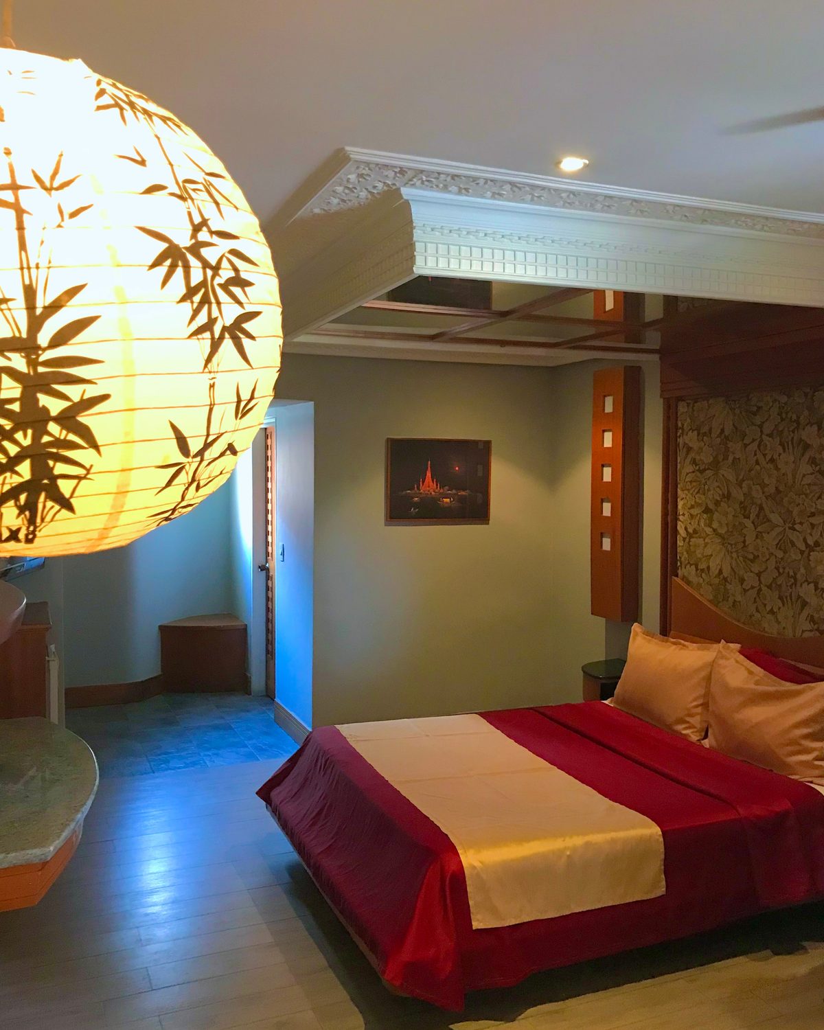 Temática Jacuzzi (Japonesa): cama con cubrecama rojo y dorado, lámpara de papel con bambú y techo con cornisa