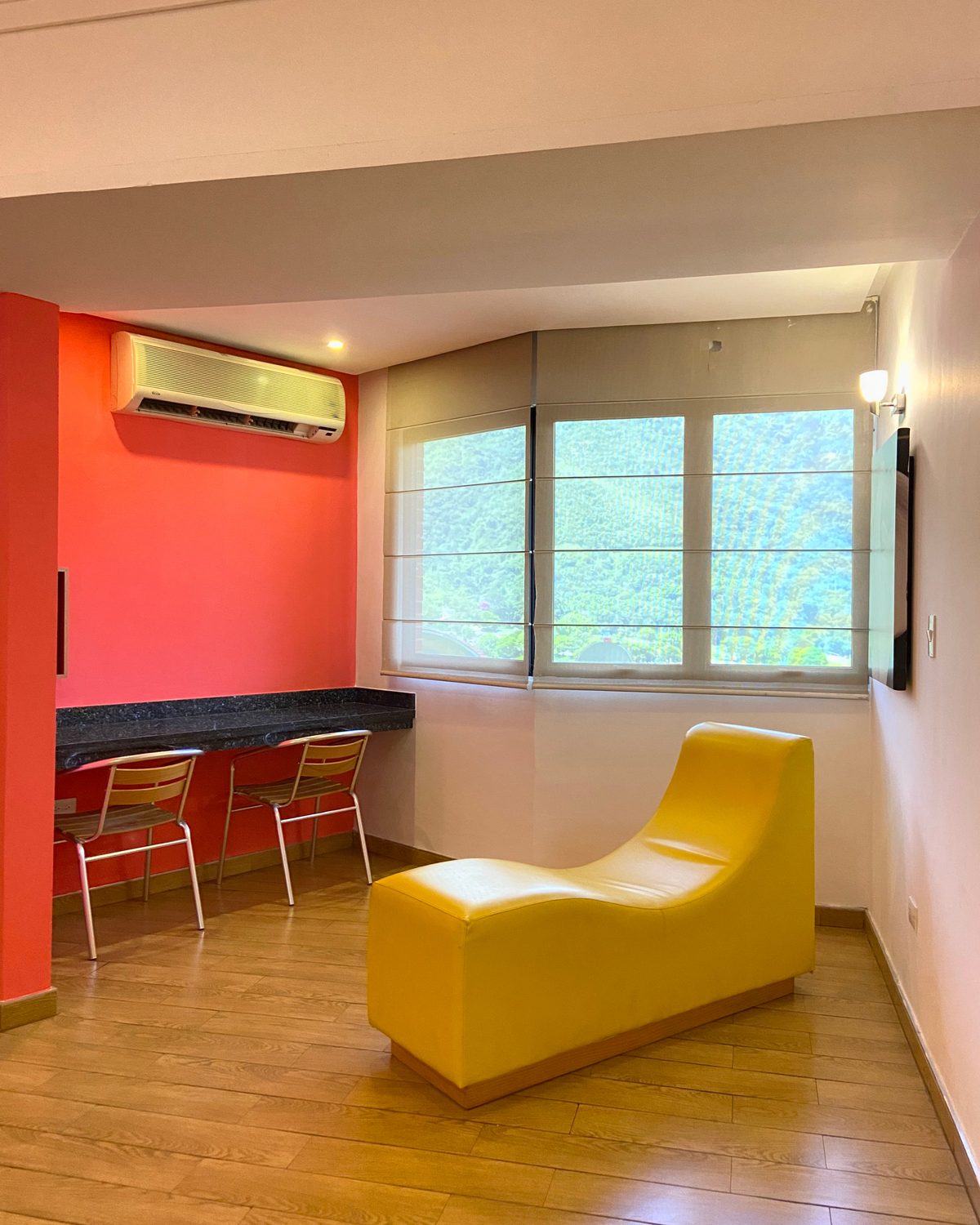 Zen: sillón amarillo estilo kamasutra, barra con dos sillas y ventana con vista a la montaña
