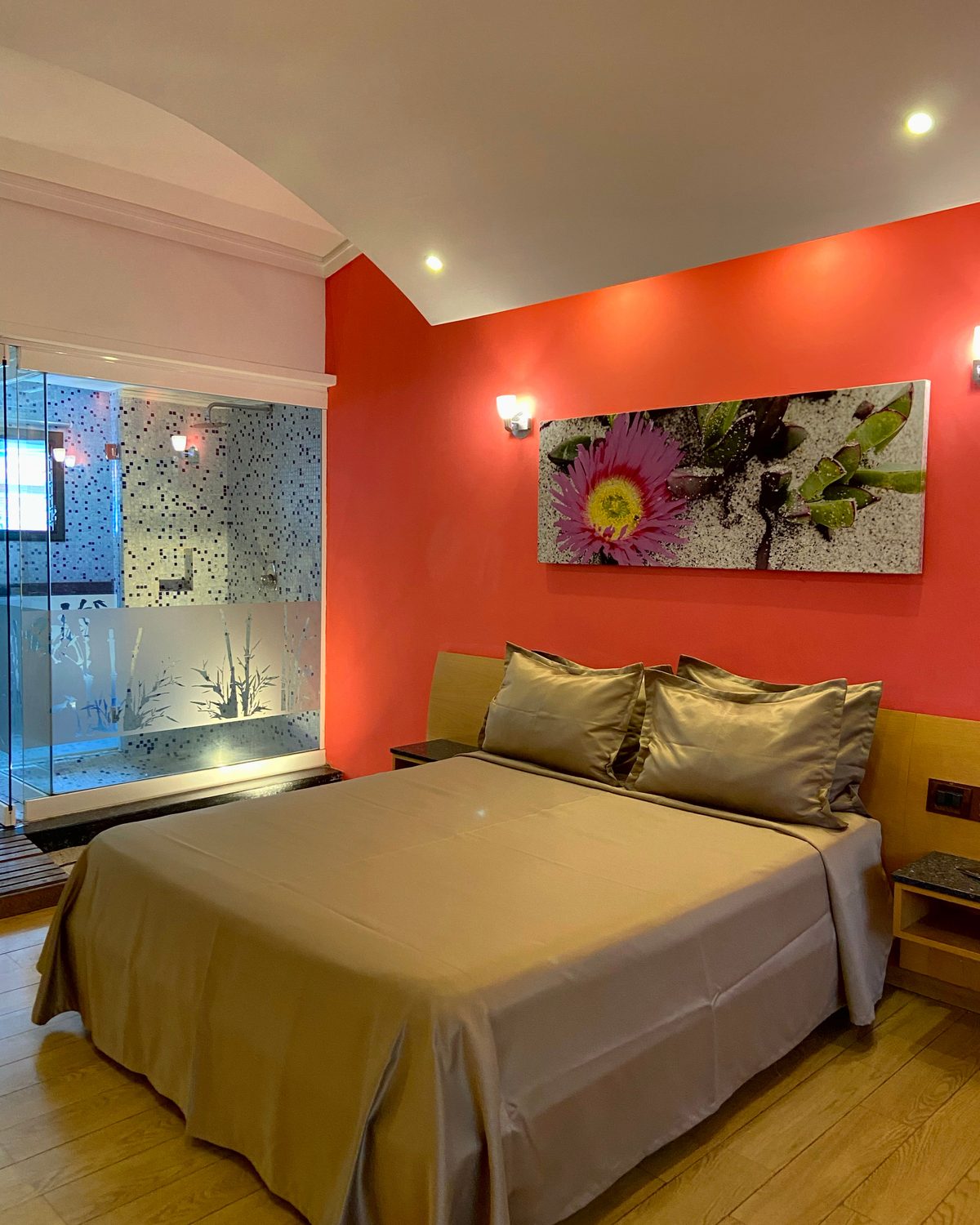 Zen: cama con sábanas de satén, pared coral con cuadro de flor y ducha de vidrio
