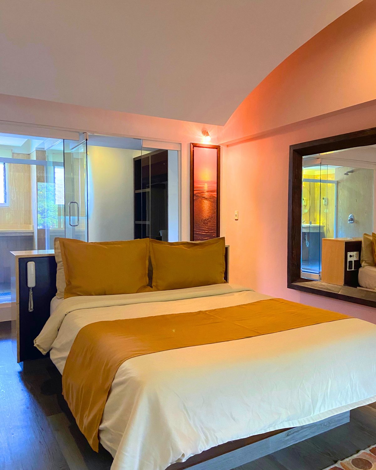 Lounge con Terraza: cama central, gran espejo y baño de vidrio al fondo