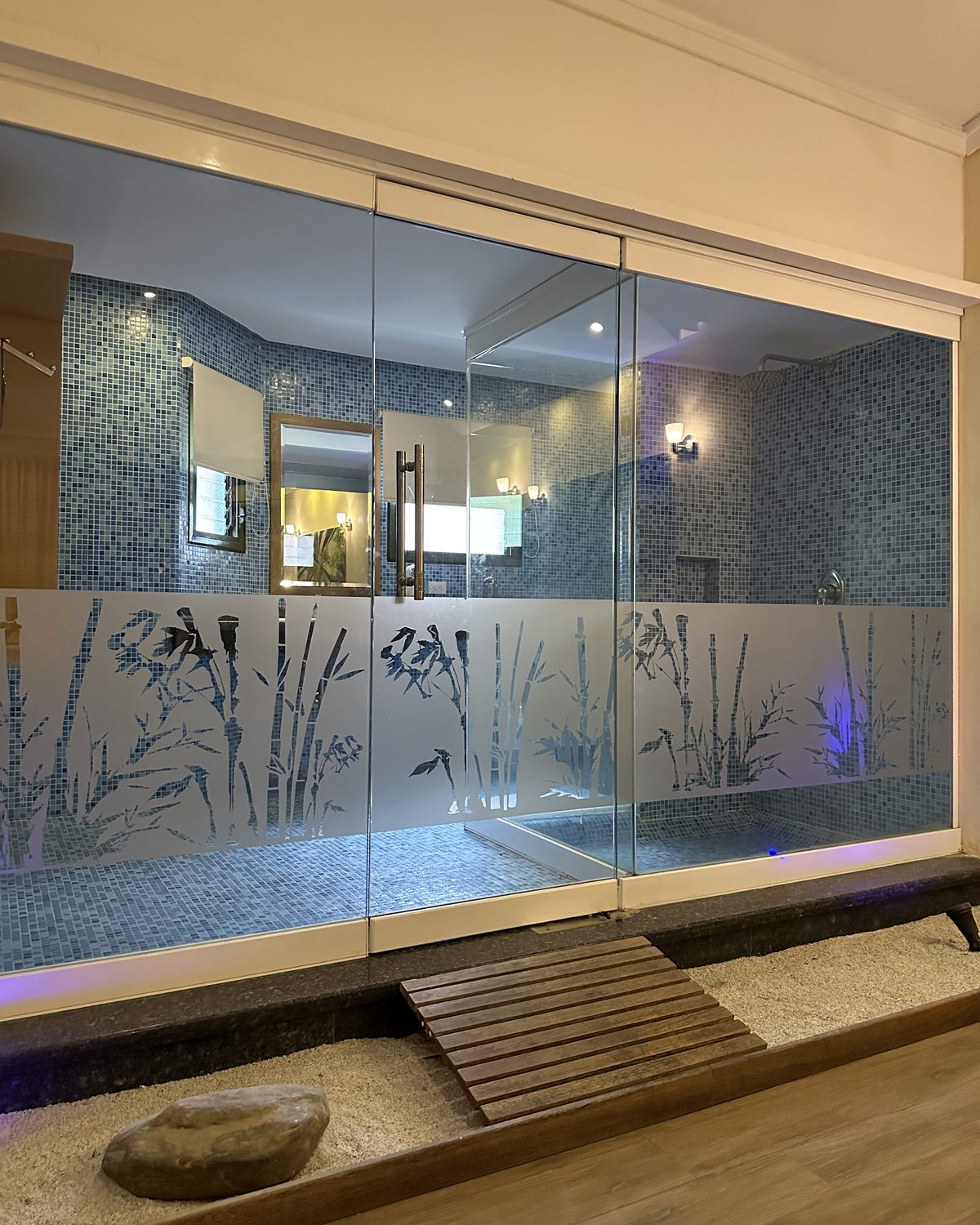 Terraza Premium: baño de mosaico con puertas de vidrio decoradas con bambú
